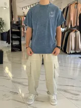 Remera oversize gris con efecto lavado ácido, manga corta y estampa en la espalda con texto y diseño de palmera.