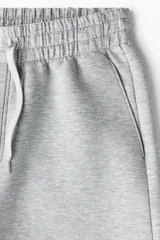 Pantalón tipo jogger de corte relajado con efecto neopreno, cintura elástica con cordón ajustable, bolsillos laterales al bies y bolsillo trasero de parche.
