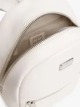 Mochila blanca de poliuretano con acabado texturizado, cierre de cremallera, asa superior, correas ajustables, bolsillo interior con cremallera, bolsillo exterior con cremallera e insignia de Tommy Jeans en la parte delantera.