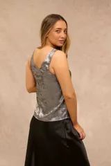 Top Gisele sin mangas de color plateado, con escote redondo y acabado metalizado con efecto desgastado.