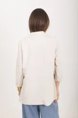 Blazer color beige de corte recto y calce relajado, con cuello de solapas, bolsillos delanteros aplicados y mangas con vuelta. Confeccionado en lino y viscosa con forro de batista.