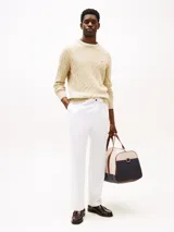 Sweater Tommy Hilfiger de punto trenzado color beige, con cuello redondo, mangas largas y puños y bajo de canalé. Incluye logo bordado en el pecho.