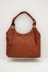Cartera tipo hobo color suela, confeccionada en cuero con diseño trenzado y correa ajustable con hebilla metálica dorada.