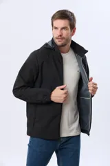 Campera repelente al agua y cortaviento de color negro, con capucha desmontable, cierre frontal y parche circular en el pecho.