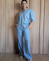 Pantalón de corte recto y holgado, confeccionado en denim azul. Presenta cintura elástica con cordón de ajuste y bolsillos laterales.