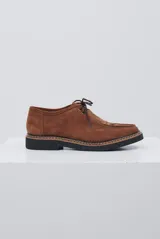 Zapato abotinado de gamuza color caramelo, con cordones, detalle de flecos en el empeine y suela de goma negra con costuras a la vista.