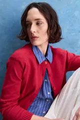 Cardigan de calce regular confeccionado en tejido de algodón y acrílico, color azul marino. Presenta cuello redondo, abertura frontal con botones y mangas largas con detalle de tejido en los hombros. Se completa con terminaciones acanaladas en puños y ruedo.