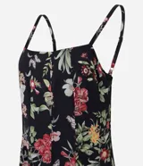 Vestido midi de corte evasé confeccionado en chiffon, con estampado floral sobre fondo negro, escote cuadrado y breteles finos.