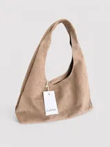 Cartera tipo hobo de diseño flexible y caída natural, confeccionada en material con textura simil gamuza. Cuenta con asa corta integrada para llevar al hombro, cierre superior y bolsillo interior con cierre.