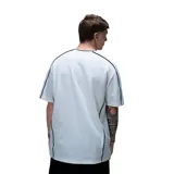 Remera de corte oversize color negro con cuello en V con detalle de ribete blanco. Presenta estampado frontal con el logo de la marca y líneas blancas laterales que recorren las mangas y el cuerpo.