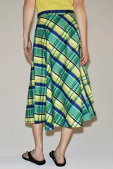 Falda midi de tiro medio marca ZWE Collection, confeccionada en hilatura de algodón con diseño de cuadros tipo tartán en tonos verdes, azules y amarillos. Tiene corte evasé y cierre lateral con cremallera oculta.