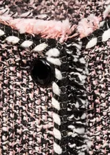 Chaqueta de tweed con diseño recto y cuello redondo. Presenta cierre frontal con botones, manga larga y cuatro bolsillos de solapa en la parte delantera. Destaca por sus terminaciones deshilachadas y ribetes en contraste.