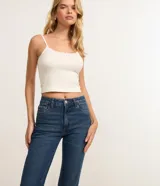 Pantalón de jean modelo flare cropped, de tiro alto, con bolsillos funcionales y cintura con trabillas. Presenta un corte ceñido en caderas y muslos con una ligera apertura acampanada desde la rodilla y ruedo deshilachado.