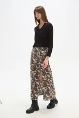 Falda larga de corte recto con abertura lateral pronunciada, confeccionada en tejido fluido con estampado abstracto en tonos tierra y crema.