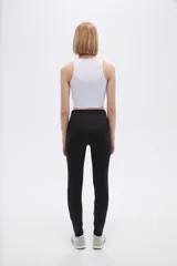 Calza negra de poliamida, corte skinny y tiro alto.