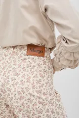 Pantalón de jean azul oscuro con estampado tipo bandana en tonos claros, de tiro medio-alto, corte recto y largo al tobillo.
