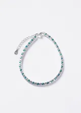 Pulsera de plata 925 tipo tennis, decorada con una fila continua de zirconias transparentes alternadas con zirconias de color turquesa. Cuenta con cierre de mosquetón y cadena de alargue.