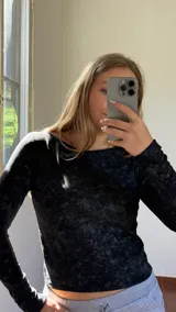 Remera térmica de manga larga con cuello bote, confeccionada en tejido jersey con efecto jaspeado en color negro.