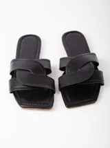 Sandalias negras de cuero sintético, con base plana y tira ancha con diseño de nudo.