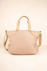 Bolso tipo shopper color beige, con asas fijas superiores y correa desmontable y regulable. Cuenta con dos bolsillos externos y tres bolsillos internos.