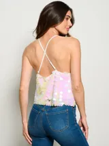 Top corto de tirantes finos cubierto completamente por lentejuelas iridiscentes en tonos pastel. Presenta un diseño cuadrado y holgado con acabado brillante.