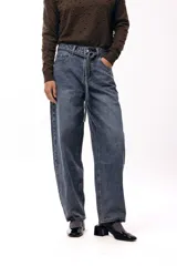 Jean de corte relajado y pierna recta amplia, con cintura media y detalle de lazo ajustable en el mismo tejido denim. Presenta un lavado azul clásico.