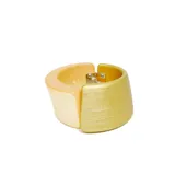 Pulsera rígida de resina combinada en tonos beige y dorado, con cierre metálico.