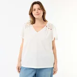 Camiseta blanca de punto crepé con escote en V y detalles de inserciones de macramé en los hombros, de manga corta y corte holgado.