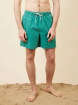 Short de baño tipo volley color verde, con cintura elástica y cordón ajustable. Presenta un diseño liso con costuras reforzadas.