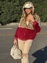 Campera tipo polar con cierre frontal, confeccionada en una combinación de tela con estampado animal print de leopardo en la parte superior y capucha, y tela lisa color bordó en la parte inferior. Cuenta con mangas largas y puños elásticos.