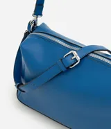 Bolso tipo shoulder de diseño rectangular estructurado en color azul. Cuenta con cierre metálico superior, herrajes plateados y correa larga ajustable y removible.