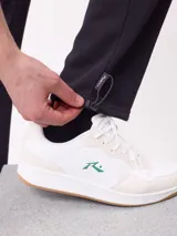 Pantalón tipo babucha de algodón y poliéster en color marrón, con cintura elástica, bolsillos laterales y logo de la marca bordado en la pierna izquierda.