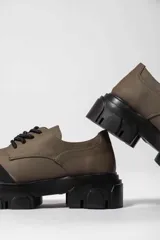 Zapato acordonado de cuero negro con suela track.