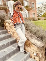 Chaleco color crema con ribete amarillo, de corte recto y sin mangas.