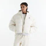 Campera puffer acolchada de color blanco marfil con capucha, cierre frontal completo y bolsillos laterales. Cuenta con el logotipo de New Balance bordado en el pecho.
