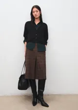 Cardigan de punto fino color negro, con cuello en V, manga larga y cierre frontal de botones.