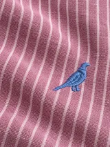 Camisa de lino de corte slim fit, con diseño de rayas verticales celestes y blancas, manga larga y cuello camisero. Cuenta con cierre frontal de botones y detalle de bordado de ave en el pecho.