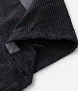 Campera liviana de poliamida con diseño cuadrillé sutil, cuello alto y cierre frontal. Presenta paneles reflectivos estratégicos para mayor visibilidad, puños elásticos y corte contemporáneo.
