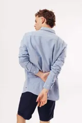 Camisa de manga larga para hombre, color azul claro jaspeado, con cuello clásico y botones blancos. Corte ajustado (slim fit).