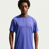Remera deportiva Nike para running con tecnología Dri-FIT, de color tostado con diseño texturizado perforado y mangas cortas raglán.