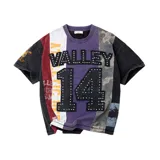 Remera negra de manga corta con diseño de paneles multicolor, aplicación de texto "VALLEY" y el número "14" en el frente con pedrería brillante.