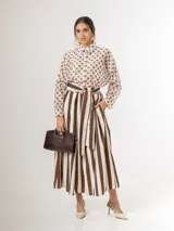 Falda midi a rayas con bolsillos laterales, cintura elastizada y lazo incorporado para ajustar en la cintura.