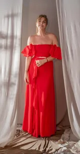 Vestido largo de fiesta color rojo, con escote asimétrico, manga corta con volados y falda con abertura lateral y volados. Ajustado a la cintura con cinturón dorado.