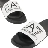 Ojotas EA7 Emporio Armani con base negra y banda superior blanca que presenta el logo de la marca en color negro.