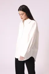 Camisa celeste de corte amplio, con cuello clásico, mangas largas y bolsillo en el pecho.