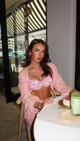 Conjunto de bikini estampado con flores y hojas en tonos rosados, amarillos y verdes. Incluye corpiño con aro y bombacha con lazos laterales.