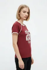 Remera de algodón blanca de manga corta estilo ringer, con cuello y puños en contraste negro. Presenta un estampado frontal con el número '28' relleno de encaje y la inscripción 'San Francisco Sports Club'.