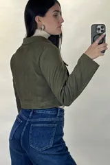 Chaqueta corta de gamuza en color verde militar, con cierre frontal metálico, cuello camisero y dos bolsillos frontales con tapa.
