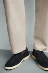 Mocasín casual de hombre, color azul marino, con parte superior de serraje (gamuza) y suela de goma a contraste color beige. Presenta un detalle de bordón cosido en la pala.