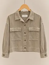 Sobrecamisa de lino color verde militar, de corte recto y holgado, con cuello clásico, cierre frontal con botones y dos bolsillos con solapa en el pecho. Presenta mangas largas con puños abotonados.